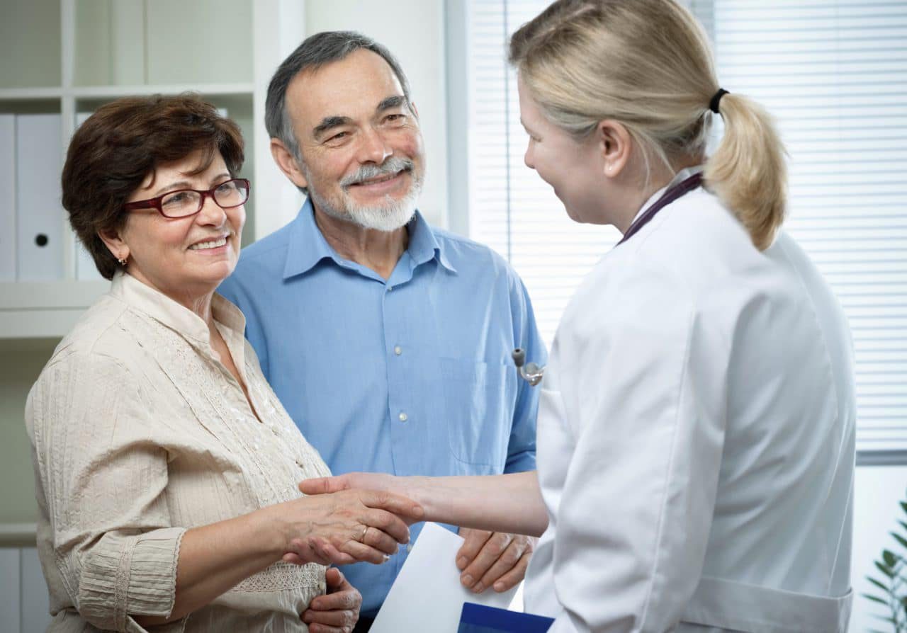 An older couple meeting with an audiologist