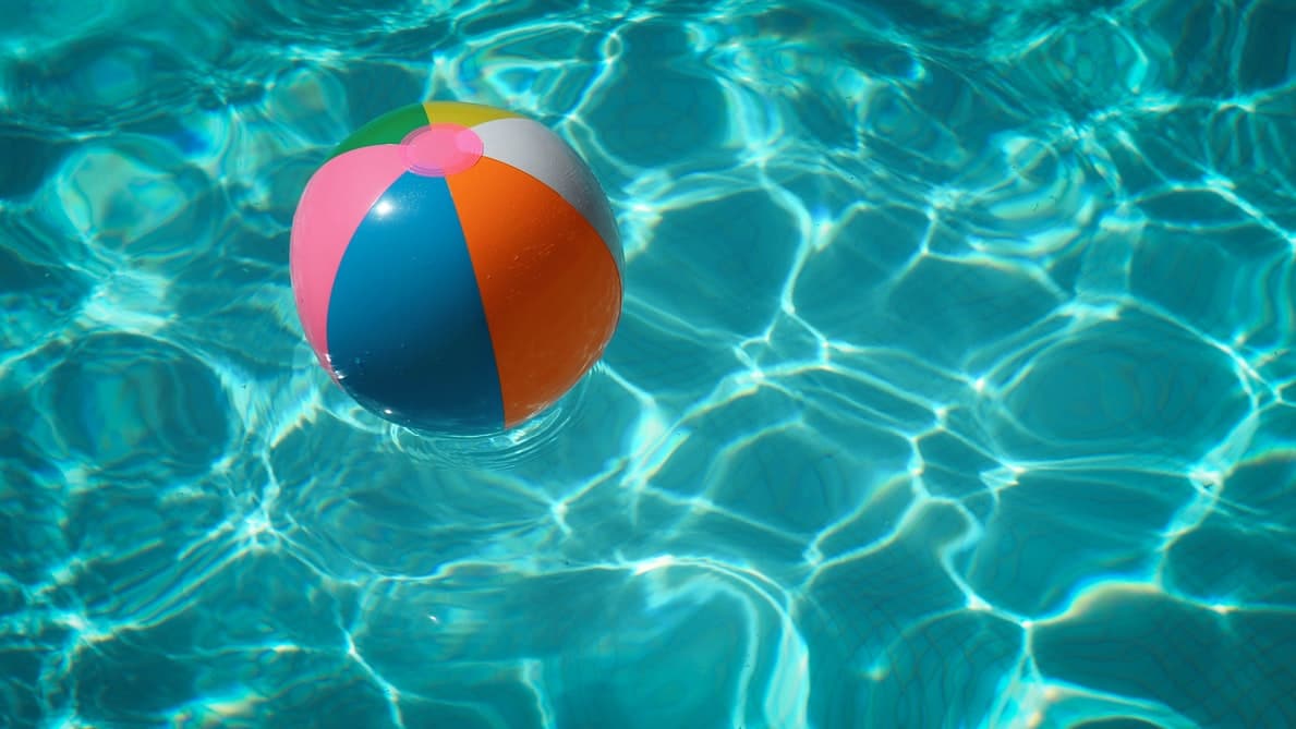 A beach ball floating around in a pool.