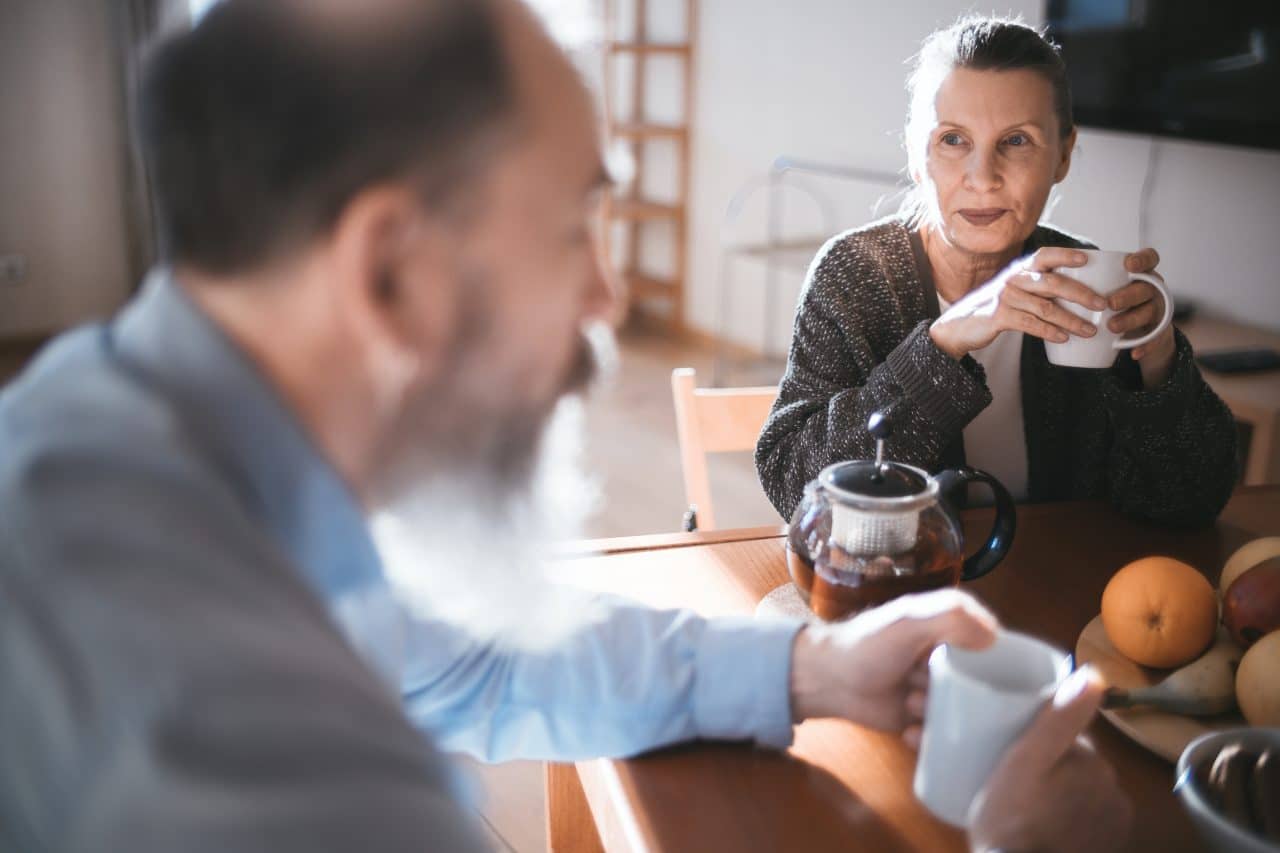 Man and woman enjoying coffee at the breakfast table.