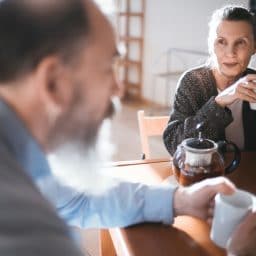 Man and woman enjoying coffee at the breakfast table.